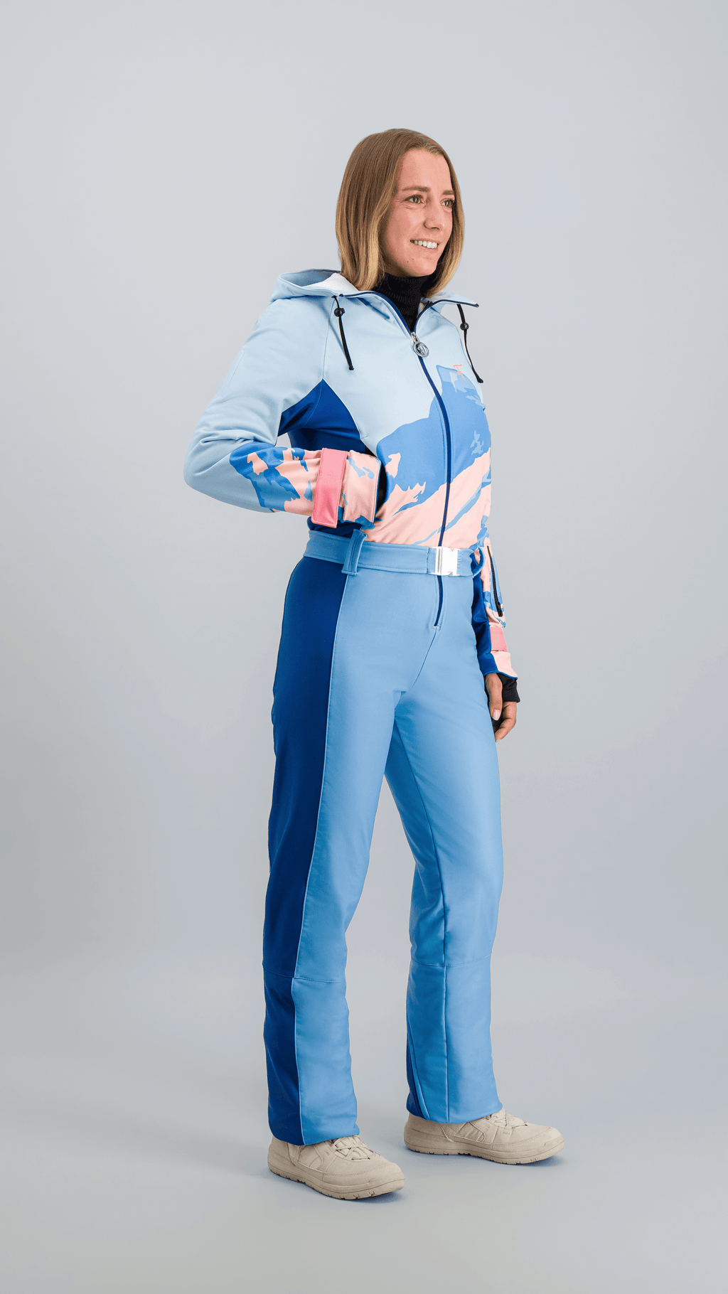 Vue de face d’une combinaison de ski bleue Fuzance, coupe ajustée et ceinture contrastée.