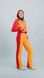 Femme en combinaison de ski Hélios rouge-orange sur fond clair avec style vintage des années 80.