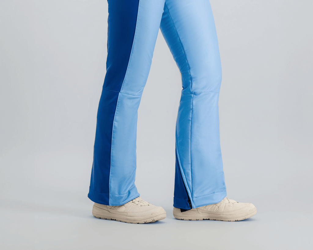 Modèle en combinaison de ski Fuzance bleu glacier, prête pour les pistes, avec détails techniques modernes.