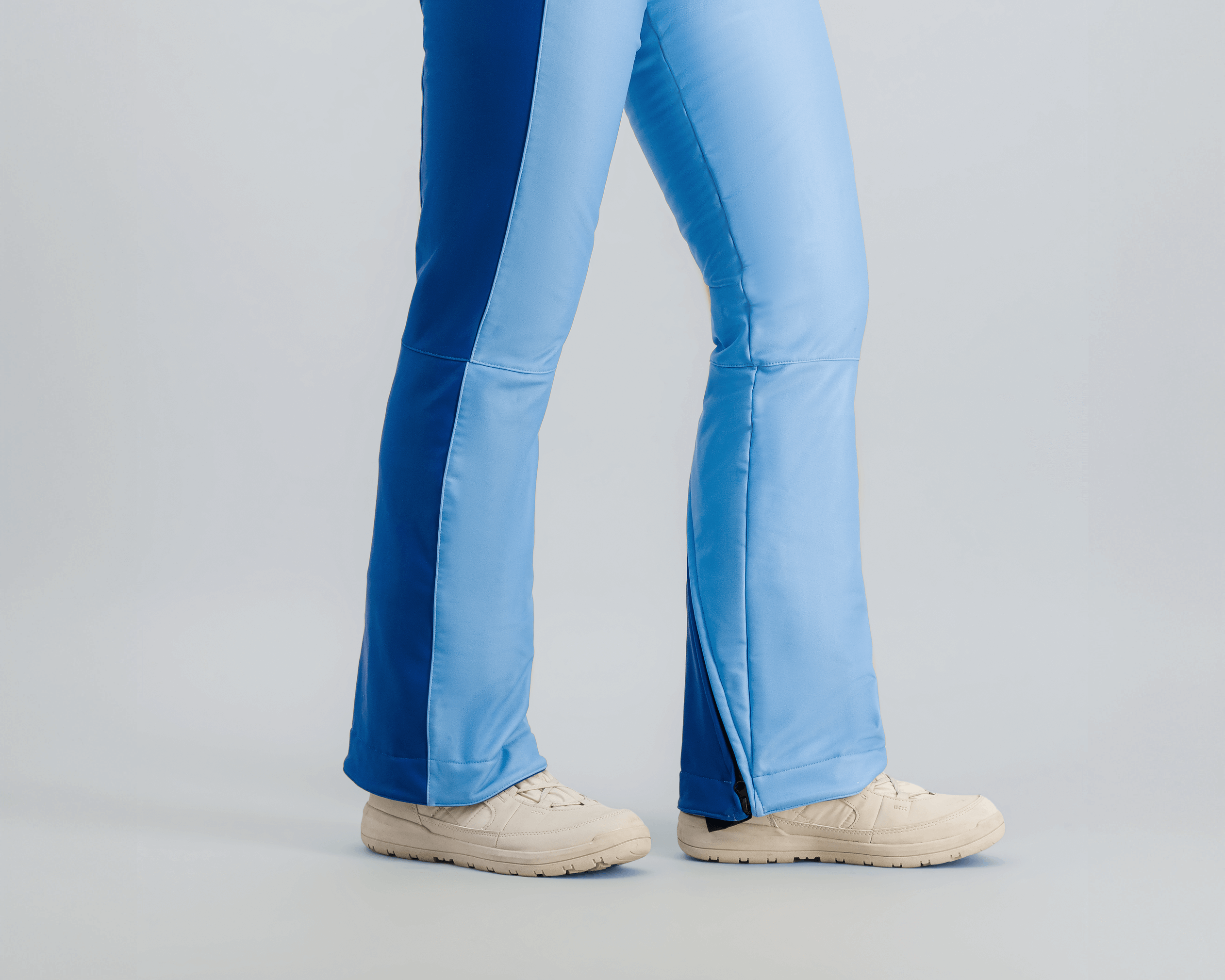 Modèle en combinaison de ski Fuzance bleu glacier, prête pour les pistes, avec détails techniques modernes.