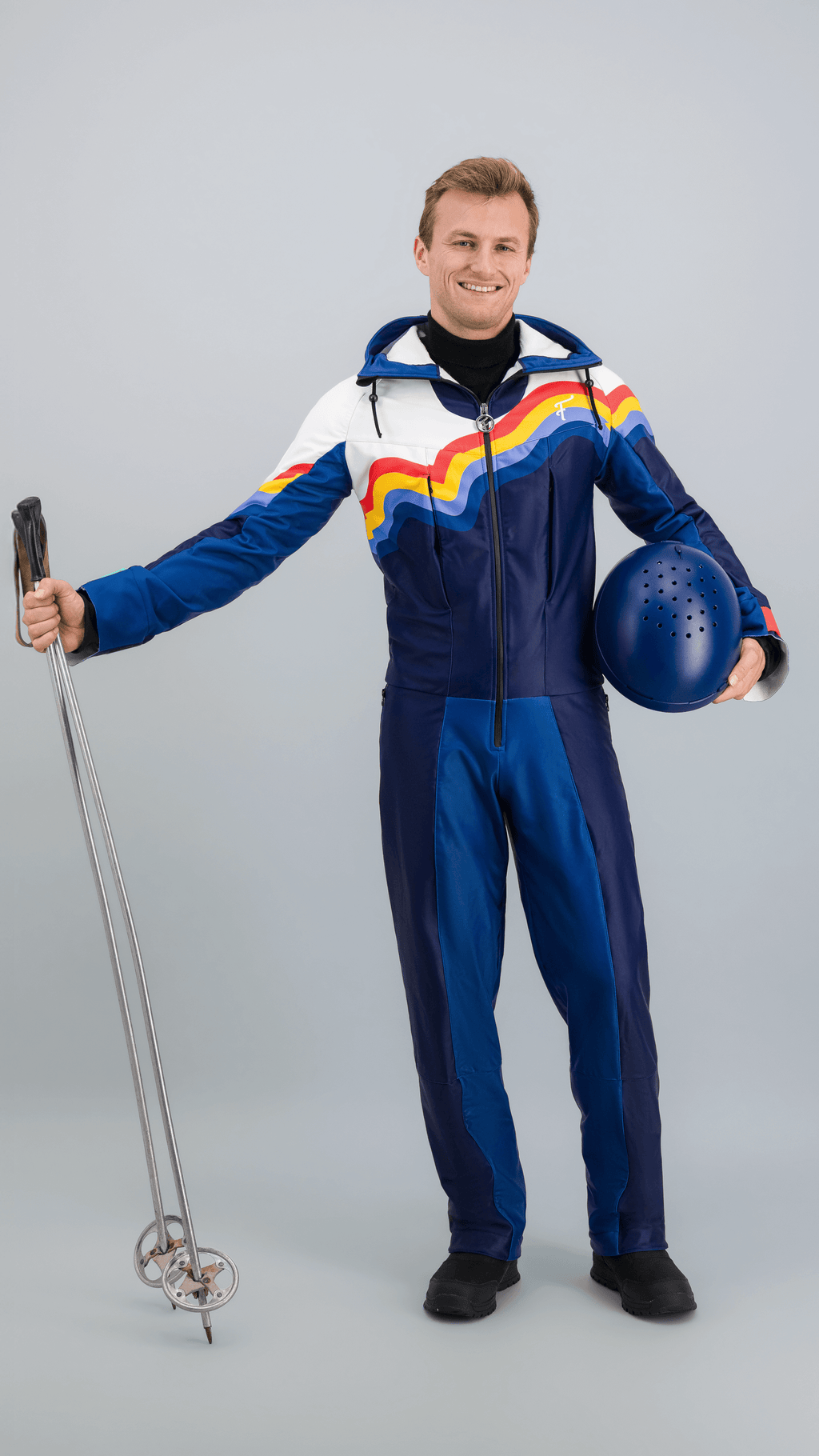 Homme portant une combinaison de ski Slalom Graphique noire avec motifs colorés, sur fond neutre.